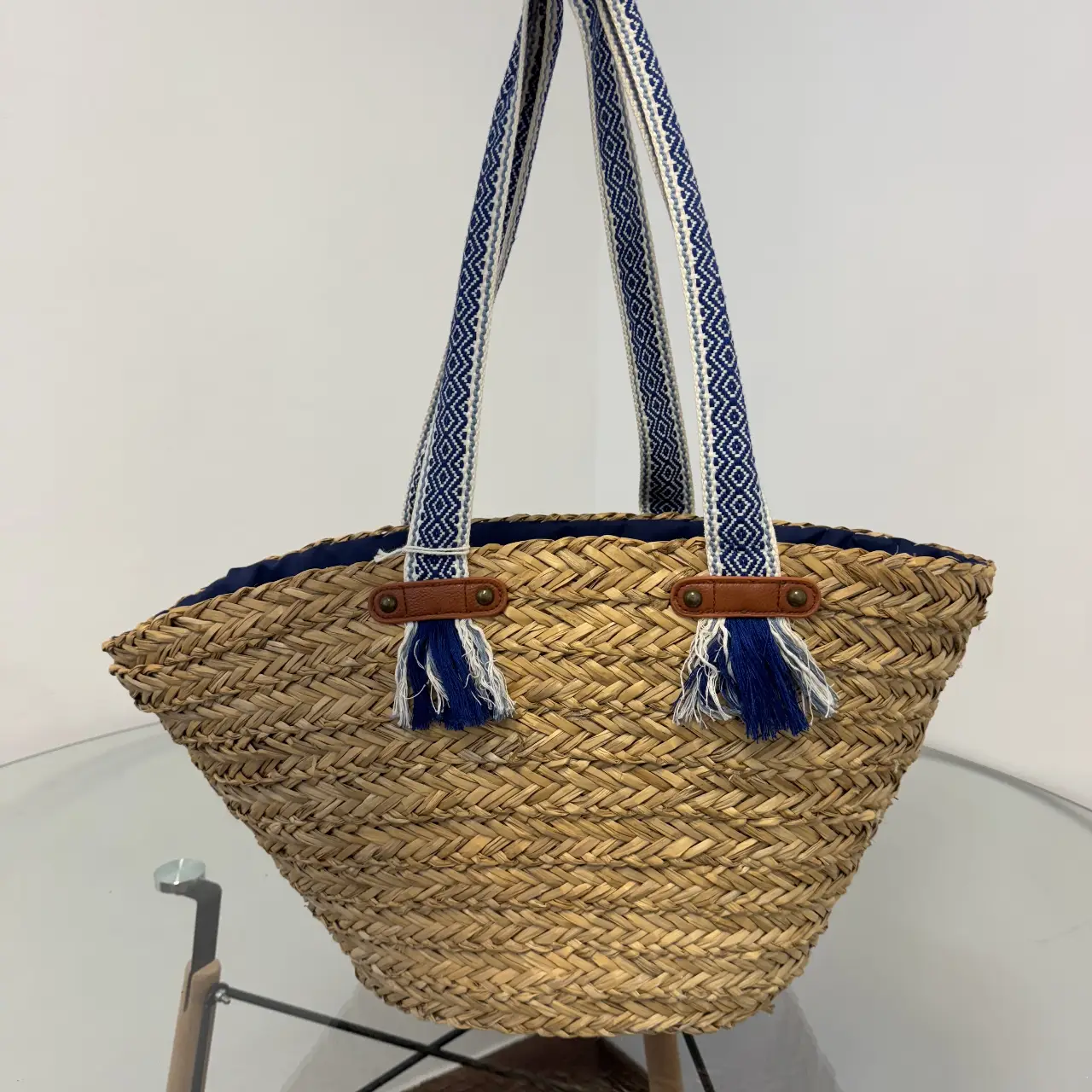 Bolso de playa artesanal de yute con detalles en azul y manijas a juego. Ideal para llevar todo lo necesario con estilo y comodidad.