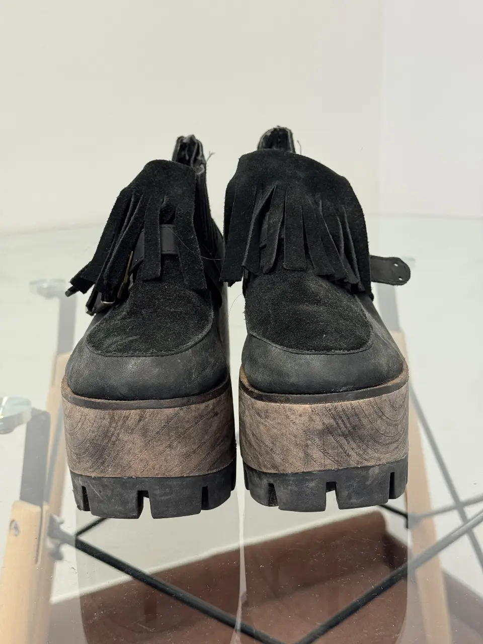 Botines negros con plataforma de madera y flecos en la parte superior. Ideales para un look casual y con estilo.