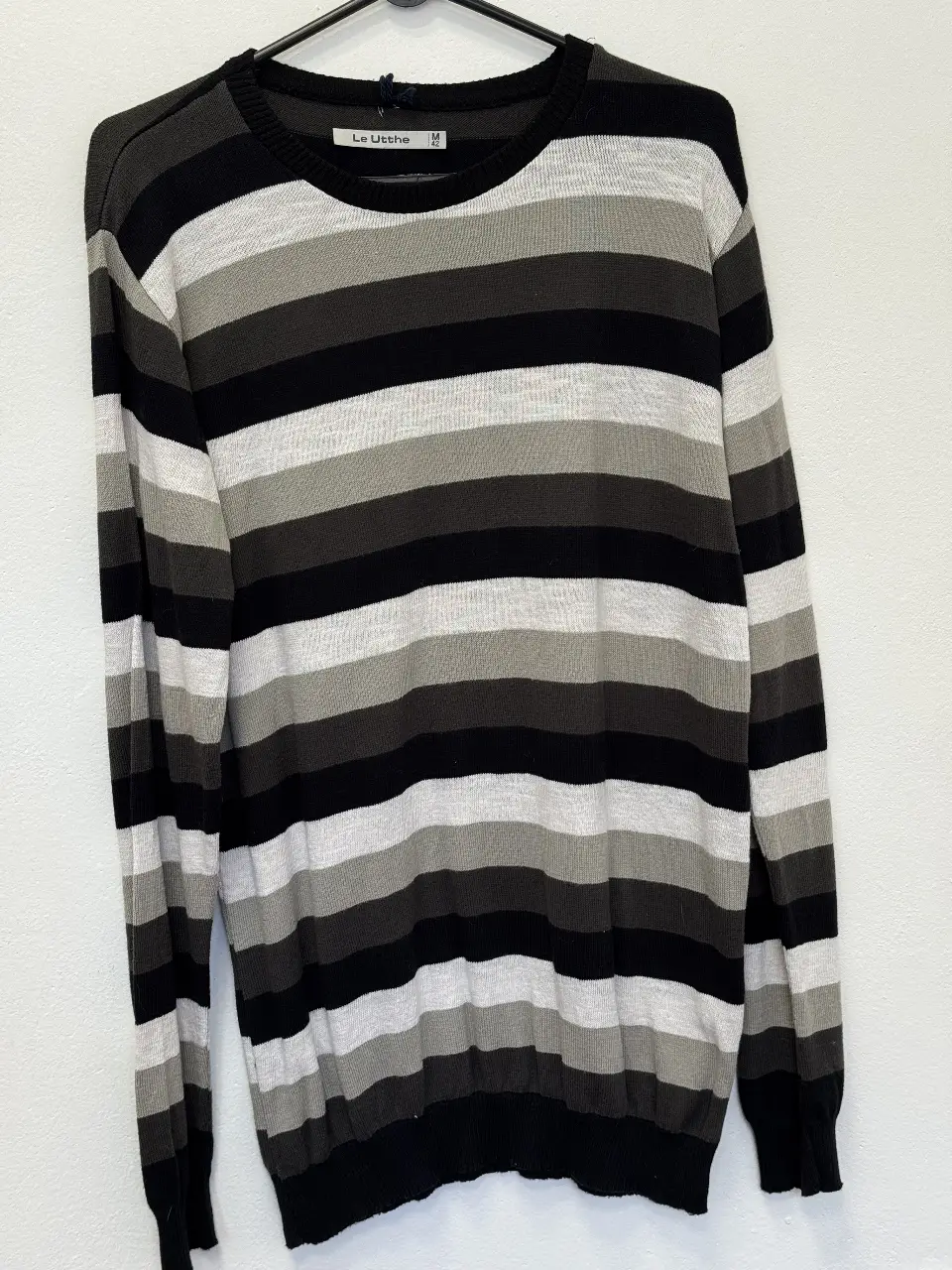 Sweater a rayas horizontales en tonos grises y negro. Cuello redondo y mangas largas. Ideal para un look casual y abrigado.