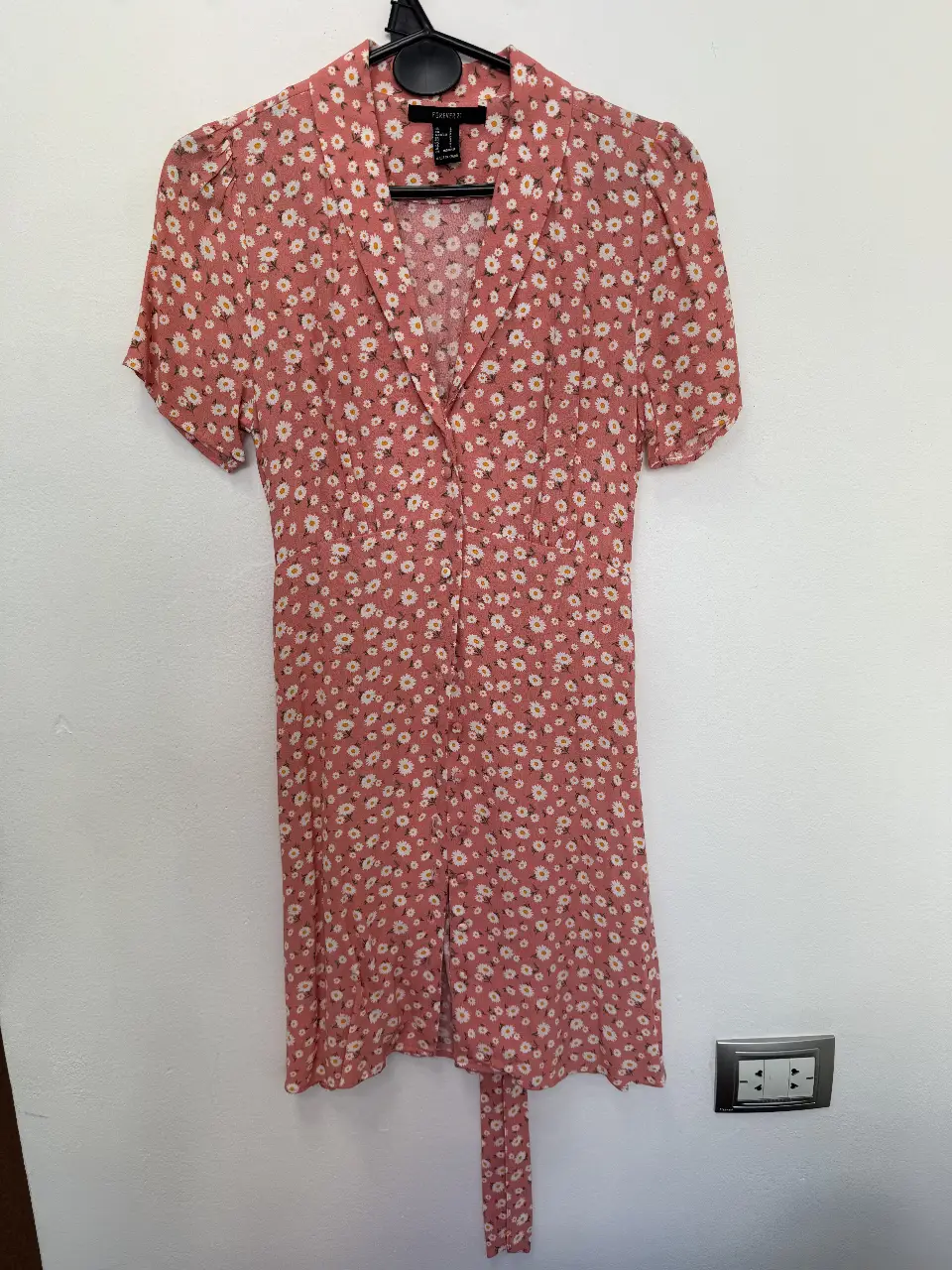 Vestido mini de Forever 21 con estampado floral en tonos rosa y blanco. Diseño con cuello camisero, botones delanteros y lazo en la cintura. Ideal para un look fresco y femenino.