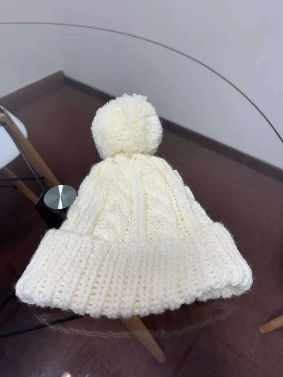 Gorro tejido de lana color blanco con pompón. Ideal para el invierno, este gorro ofrece abrigo y estilo. Perfecto para combinar con cualquier outfit casual.