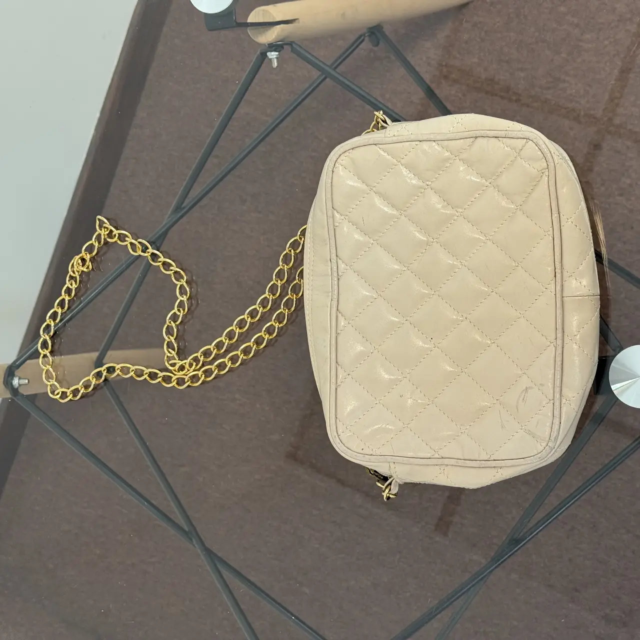 Cartera bandolera acolchada en color crema, con cadena dorada. Ideal para un look elegante y casual.