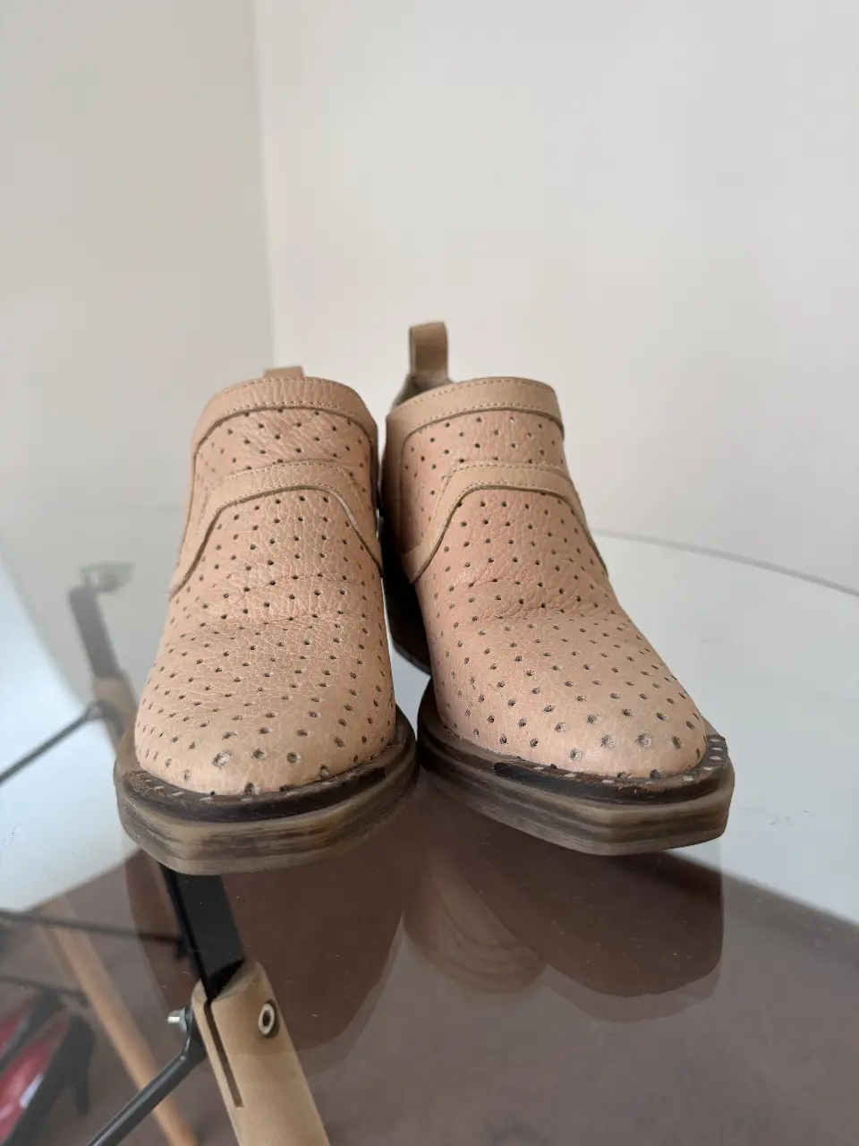Botines de cuero perforado en color crudo, ideales para un look casual y moderno. Con detalles de diseño que los hacen únicos.