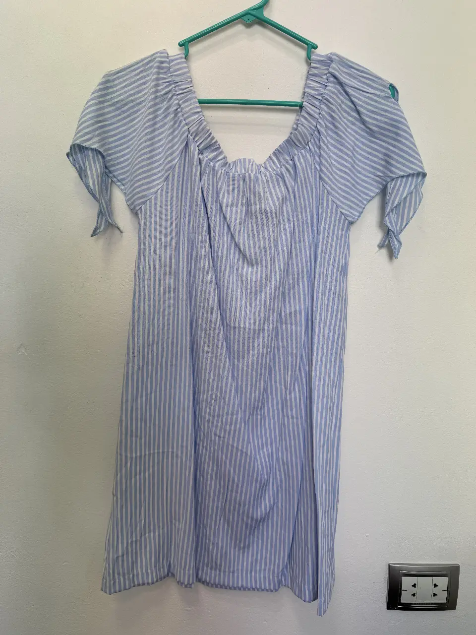 Vestido mini de mujer, con diseño a rayas verticales en tonos azul y blanco. Tiene mangas cortas con lazos y un escote cuadrado. Ideal para un look fresco y casual.