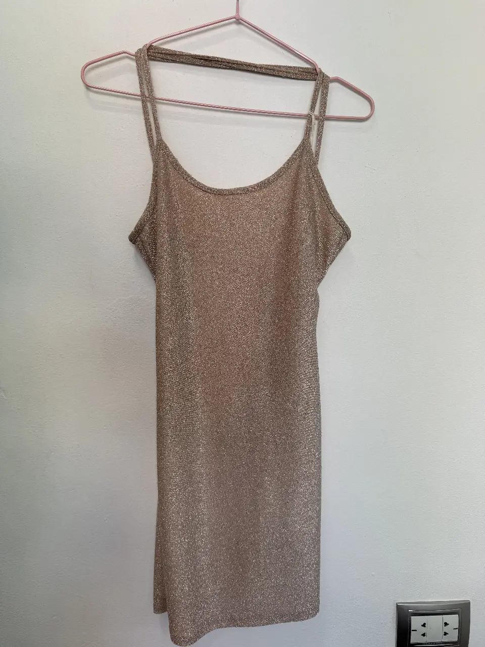 Vestido mini dorado con espalda descubierta y tiras finas. Ideal para fiestas y eventos especiales.