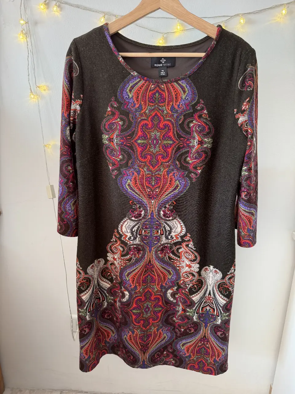 Vestido midi de Ronni Nicole con estampado paisley en tonos rojos, morados y blancos sobre un fondo marrón oscuro. Talle 14.