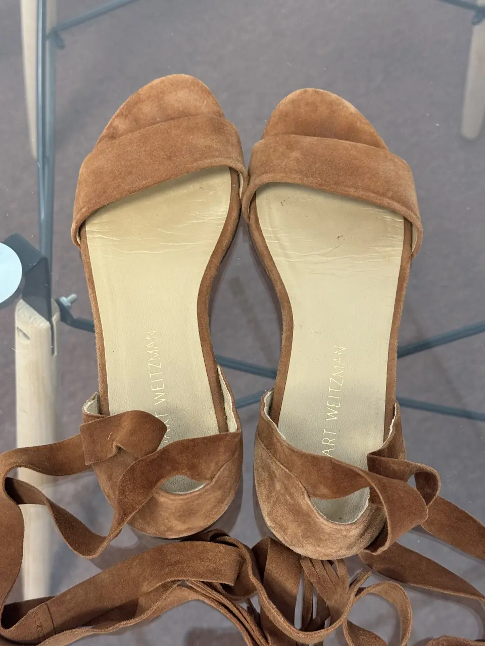 Sandalias planas de gamuza marrón con tiras para atar al tobillo. Ideales para un look casual y cómodo.
