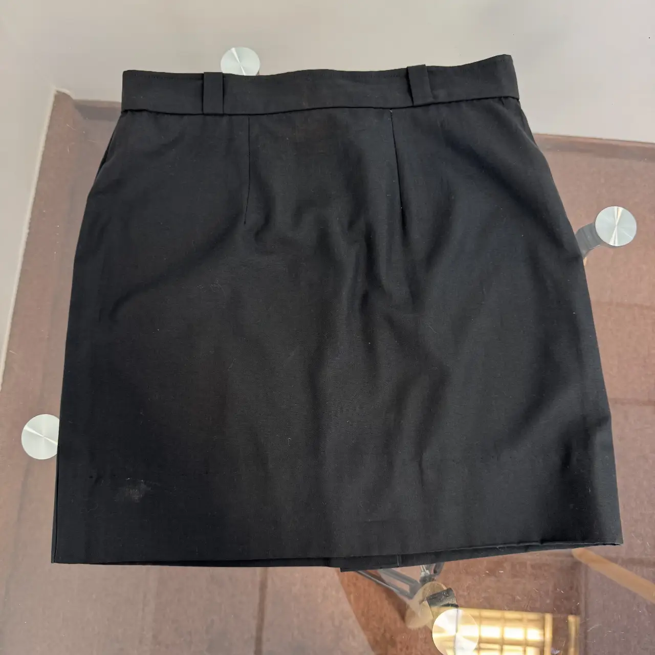 Minifalda negra de corte clásico, ideal para un look versátil. Confeccionada en un tejido resistente y de buena caída, perfecta para combinar con diferentes estilos.
