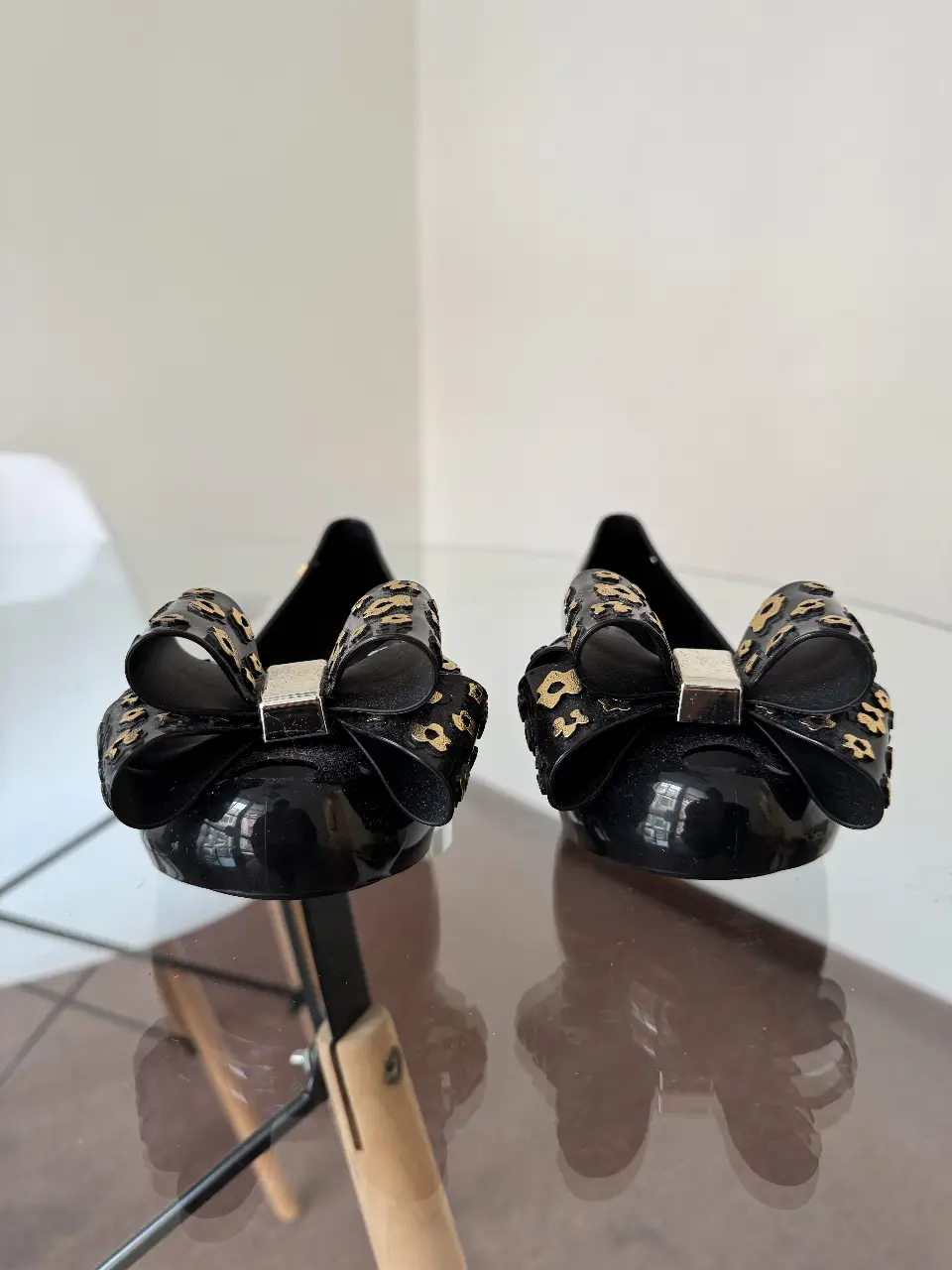 Ballerinas negras con moño y detalles dorados. Diseño elegante y cómodo, ideales para un look casual o de fiesta.