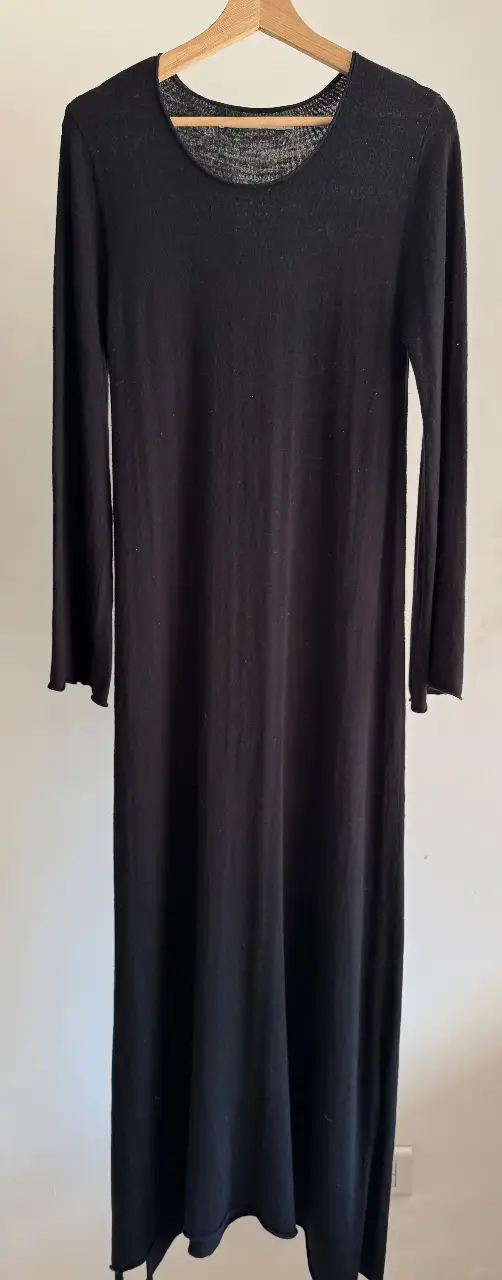 Vestido largo negro de Cher, con mangas largas y cuello redondo. Ideal para un look elegante y versátil.
