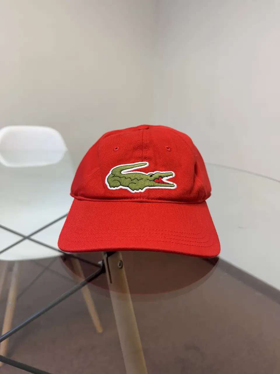 Gorra Lacoste roja unisex, con el logo del cocodrilo bordado en verde y blanco. Talla única, ideal para un look casual y deportivo.