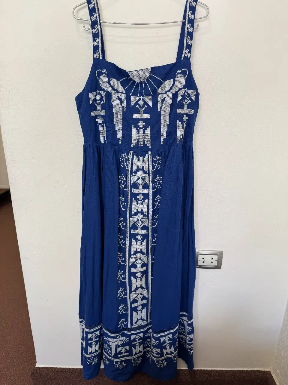 Vestido largo azul con bordados blancos. Diseño artesanal con detalles geométricos y tirantes. Ideal para un look bohemio y fresco.
