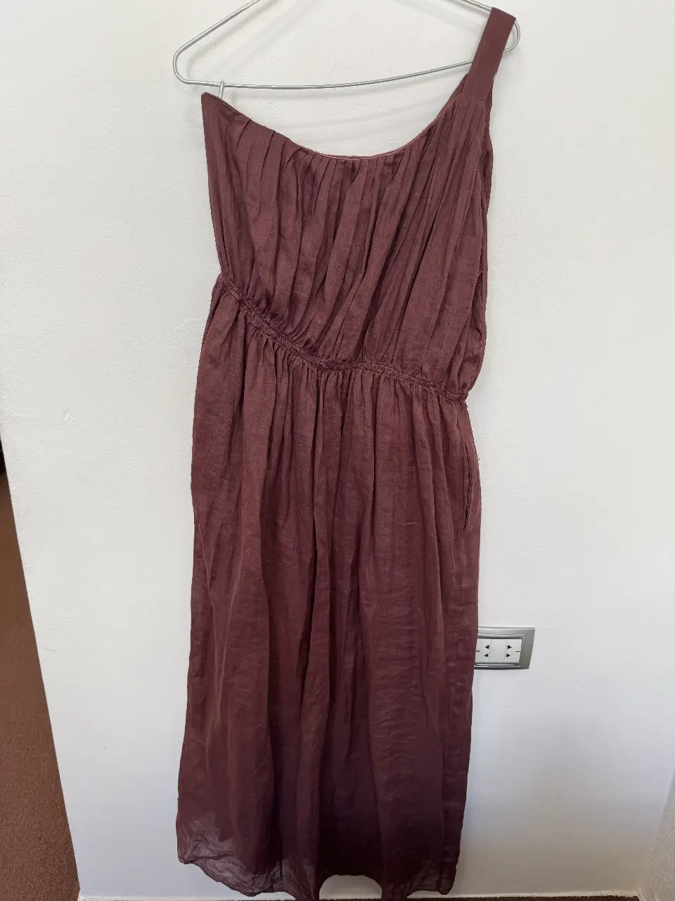 Vestido midi de un solo hombro en color marrón. Diseño drapeado en la parte superior y cintura con elástico. Ideal para un look elegante y cómodo.