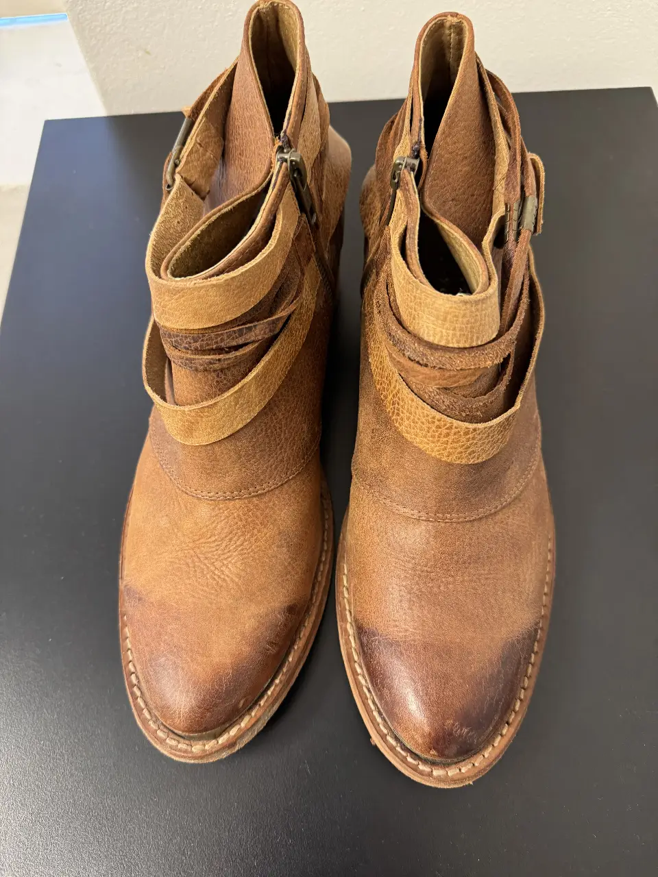 Botines de cuero marrón con detalles de correas y hebillas. Estilo boho y casual, ideales para un look de otoño/invierno.
