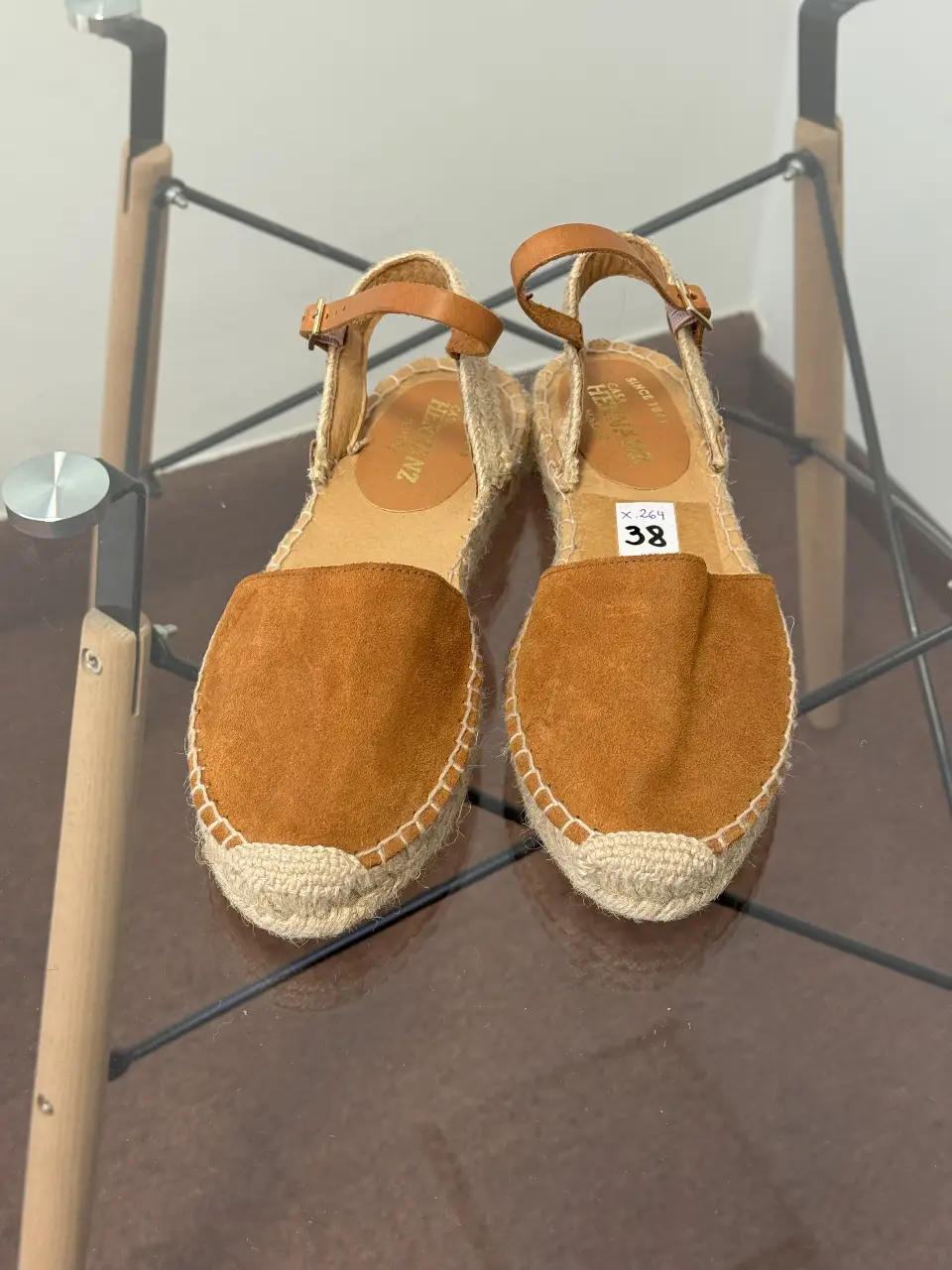 Sandalias de mujer estilo alpargata, con capellada de gamuza marrón y suela de yute. Tienen pulsera con hebilla para un ajuste seguro y cómodo. Ideales para un look casual y fresco.