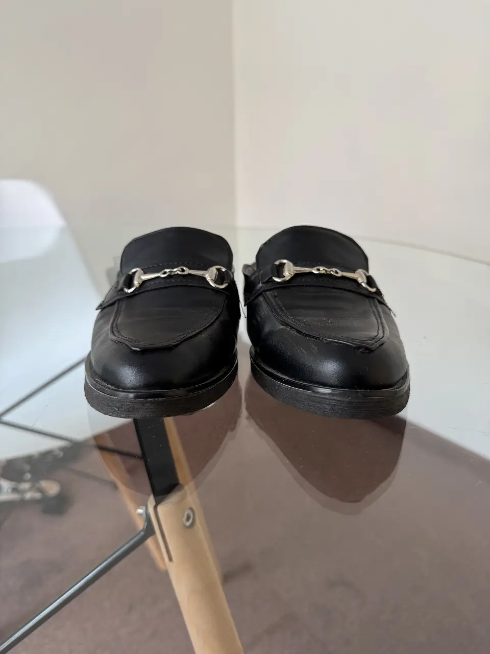 Mocasines negros de cuero con detalle de herraje plateado. Un clásico atemporal para un look elegante y sofisticado.