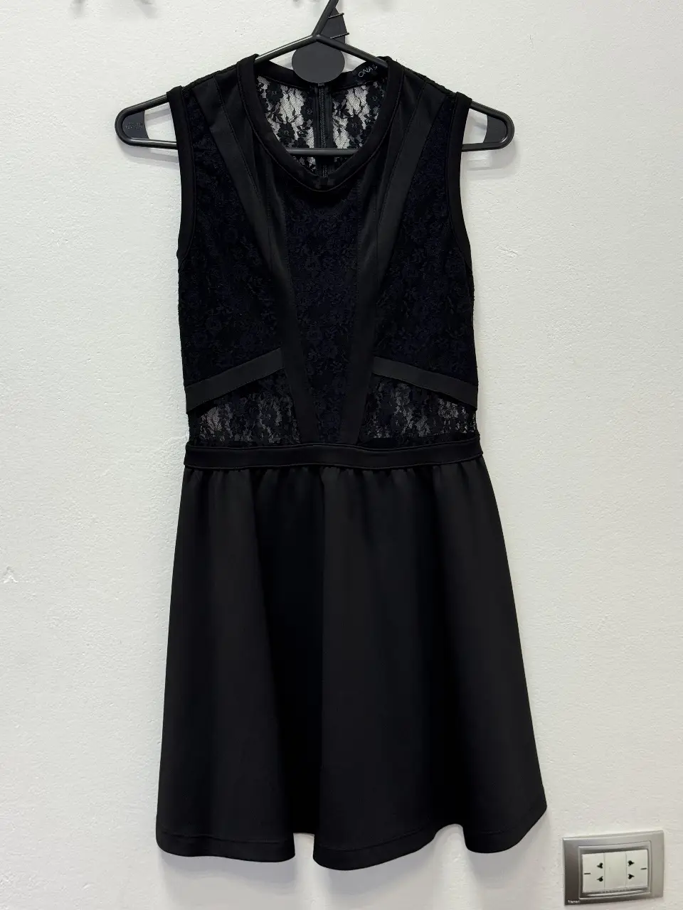 Vestido negro mini con detalles de encaje y corte en la cintura. Ideal para una salida o fiesta.