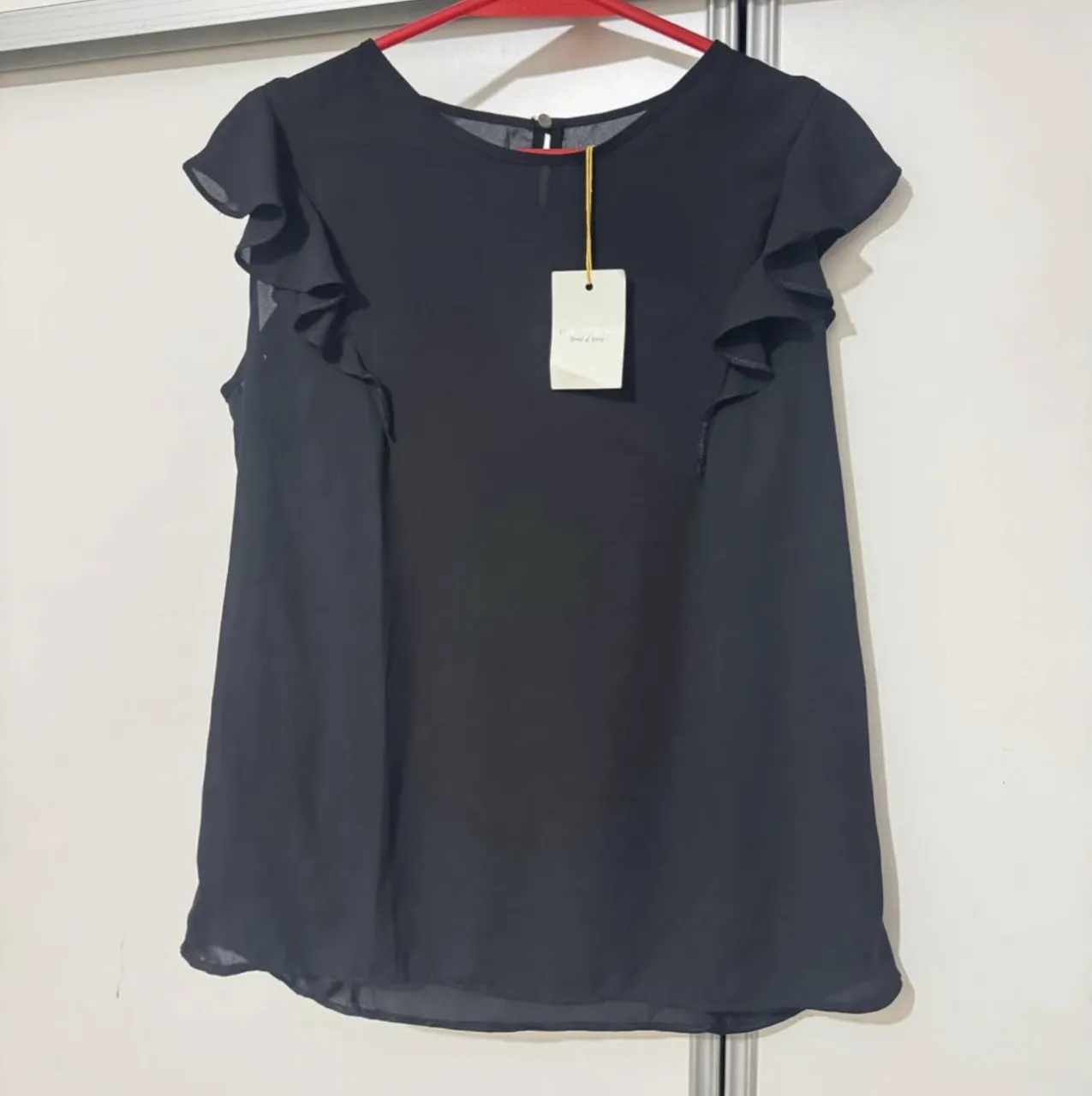 Blusa negra con mangas cortas con volados. Ideal para una salida o para el trabajo.
