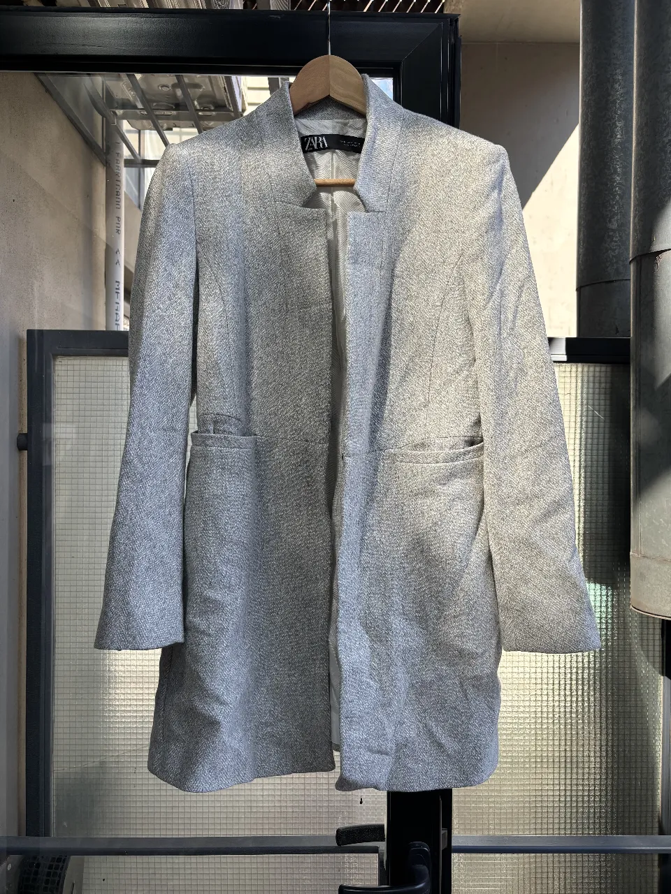 Elegante blazer gris de la marca Zara, ideal para un look formal o de trabajo. Confeccionado en un tejido de calidad, este blazer ofrece un corte clásico y sofisticado. Perfecto para combinar con pantalones sastreros o faldas.