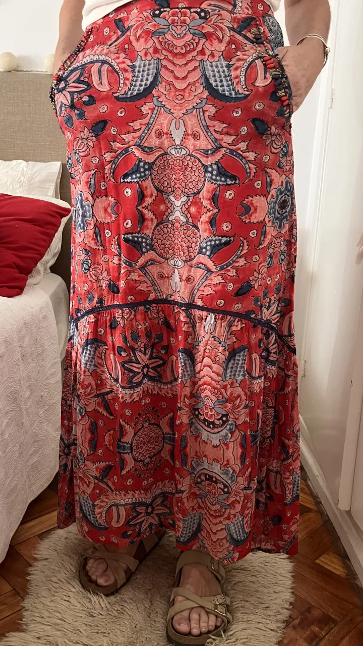 Pollera larga estampada con detalles de cuentas en los bolsillos. Ideal para un look boho chic o casual.