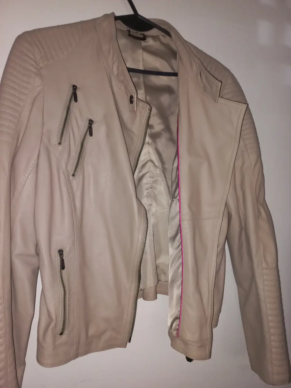 Campera Prüne 100% cuero ovino color crudo, con detalles de cierres en mangas, pechera y bolsillos. Importada. A estrenar sin etiqueta. Ideal para un look moderno y canchero.