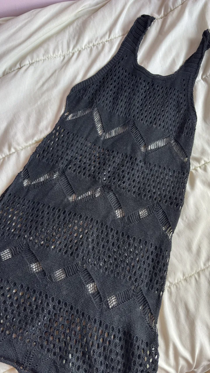 Vestido largo de tejido negro con detalles de crochet y aberturas.