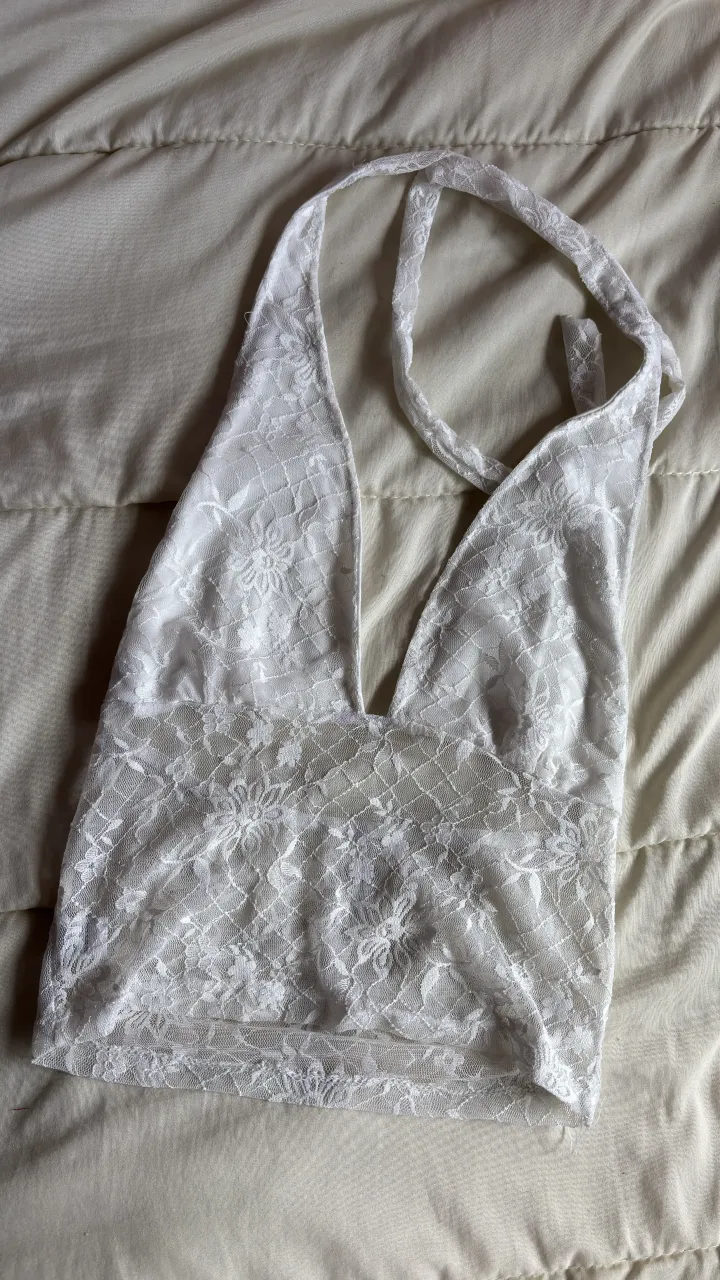 Top blanco de encaje con escote en V profundo y tiras al cuello.