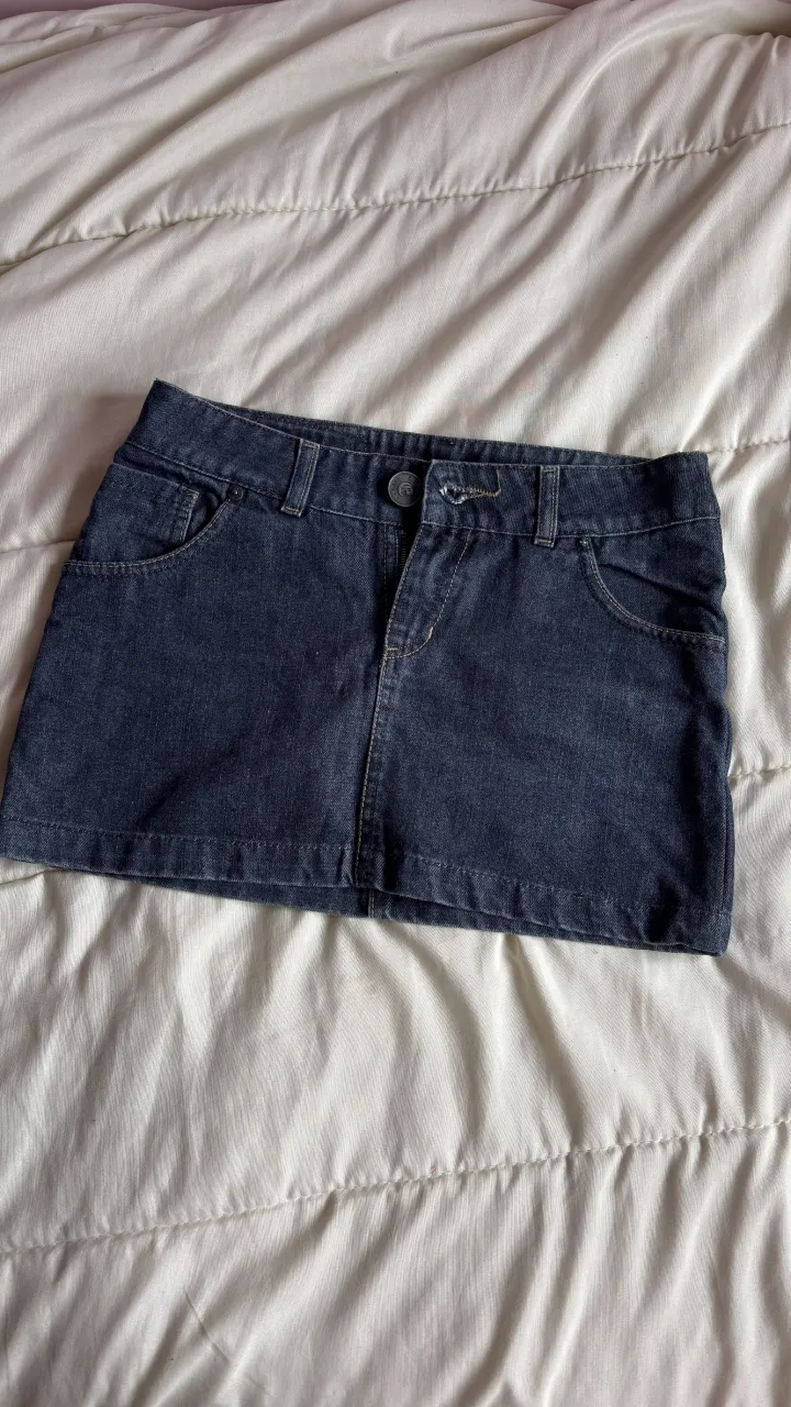 Pollera de jean azul oscuro, con bolsillos delanteros y traseros.