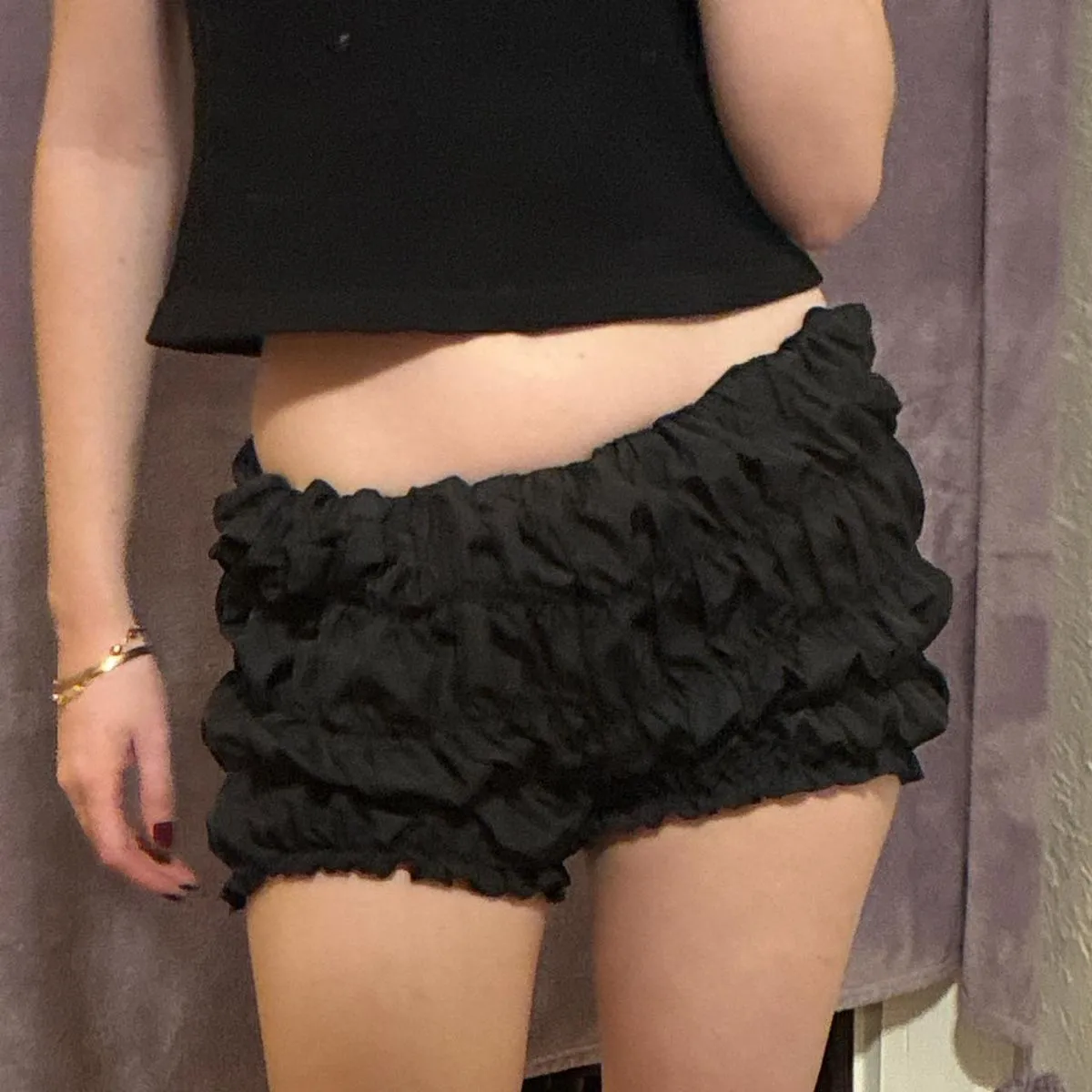 Shorts negros con volados y elástico en la cintura y en los bordes inferiores.