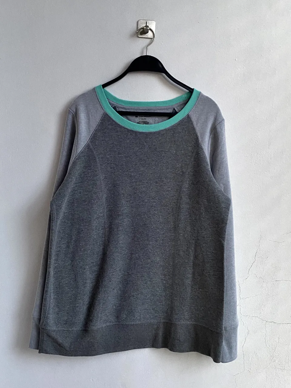 Buzo de cuello redondo para hombre, de color gris con detalles en verde en el cuello. Confeccionado en una mezcla de algodón y poliéster, ideal para un look casual y cómodo.