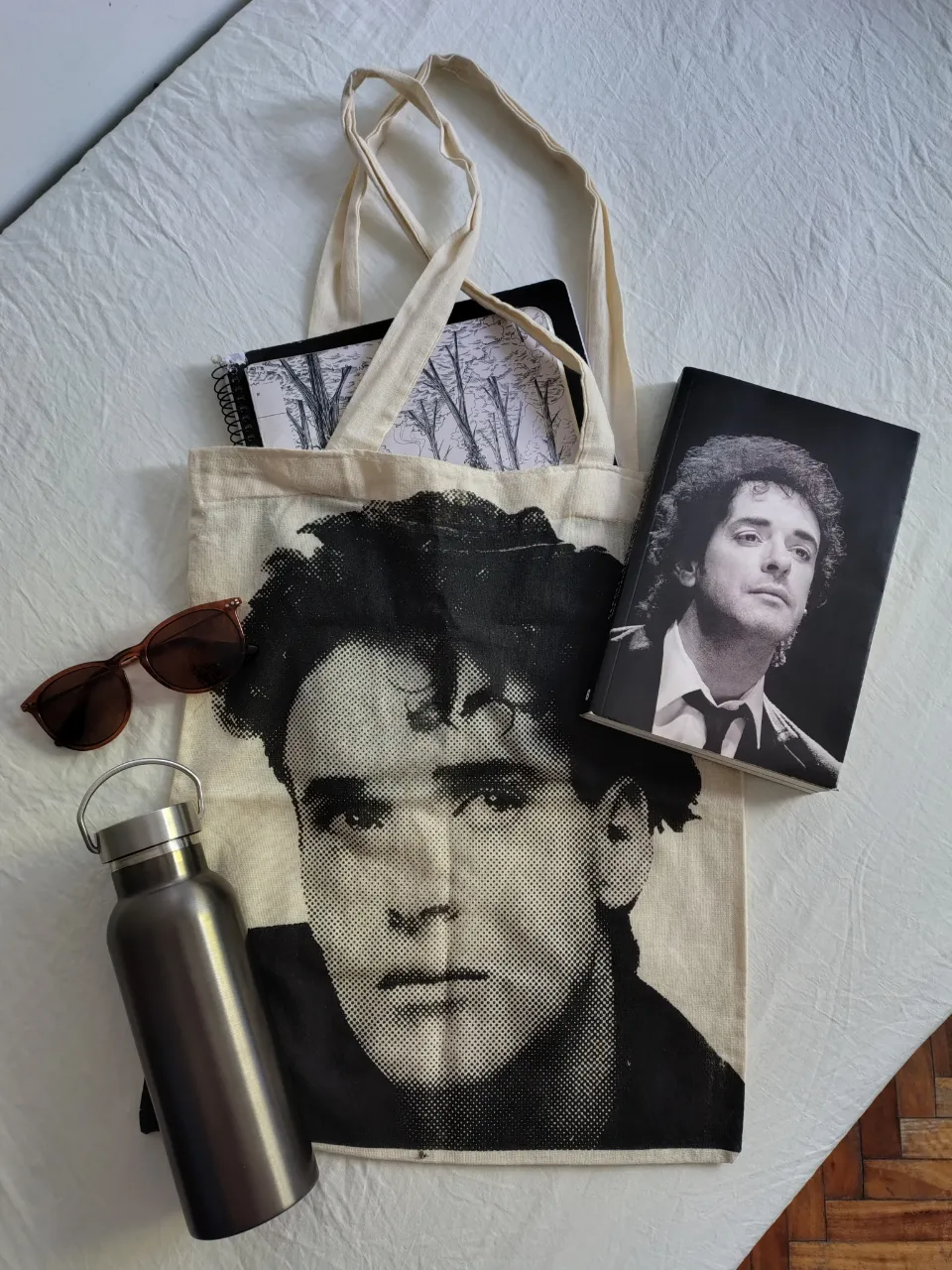 Bolsa de tela tote bag con estampa de retrato de Gustavo Cerati. Ideal para llevar tus esenciales con un toque artístico y retro. Perfecta para el día a día, para ir a la facultad o para un paseo.