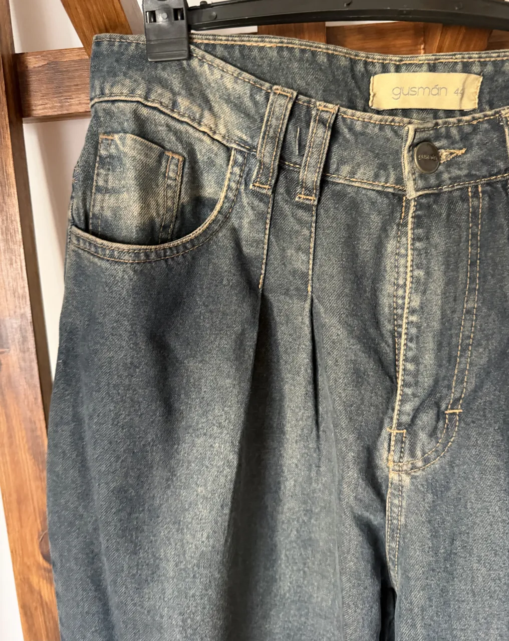 Jeans de corte recto, tiro alto, con detalles de pinzas en la parte delantera. Lavado desgastado en tono azul oscuro. Ideales para un look casual y moderno.