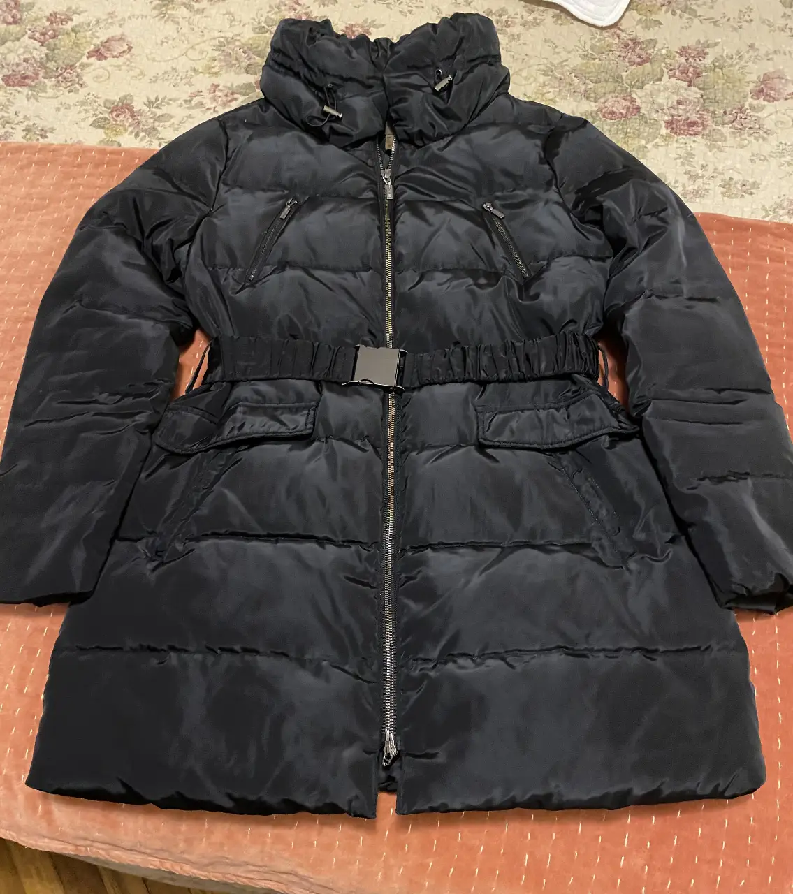Campera de pluma negra para mujer, con cierre y cinturón. Ideal para el invierno.