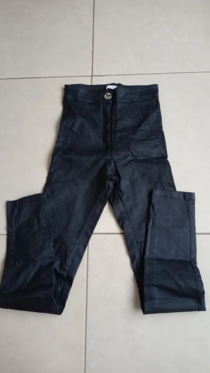 Pantalón negro tiro alto engomado, con un botón y cierre. Ideal para un look canchero y moderno.