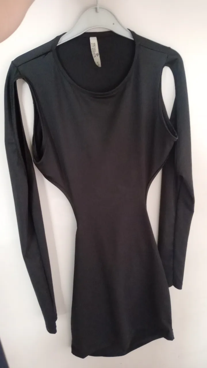 Vestido negro con mangas largas y recortes en la cintura y espalda. Ideal para una noche de fiesta o salida.