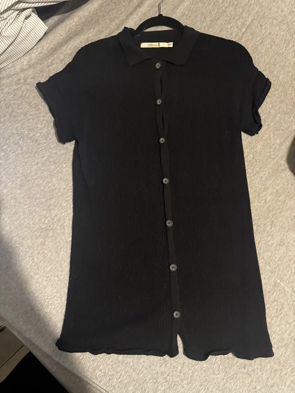 Vestido midi negro de punto con botones delanteros y cuello camisero. Ideal para un look casual y versátil.