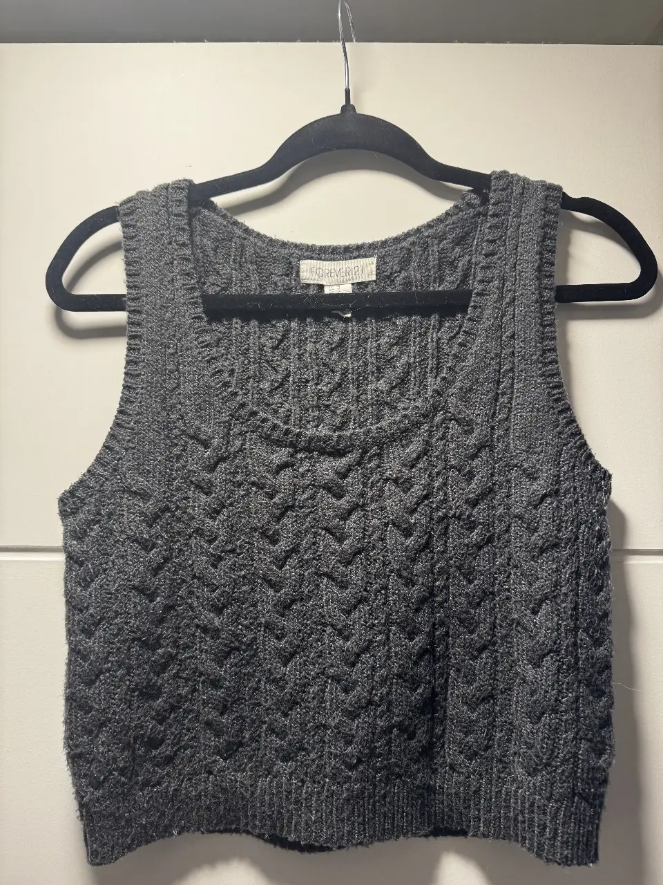 Chaleco tejido de Forever 21, ideal para un look casual y abrigado. Confeccionado en un tejido de punto grueso, presenta un diseño con textura en relieve y cuello redondo. Perfecto para combinar con camisas o remeras.