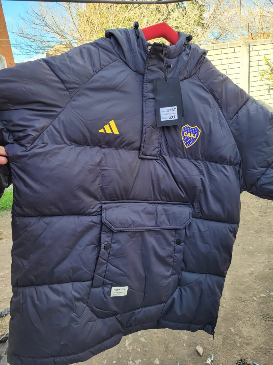 Campera inflable azul marino con detalles amarillos y escudo del Boca Juniors. Ideal para el invierno, con capucha y bolsillos.