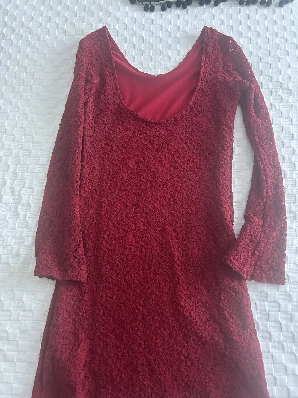 Vestido midi de encaje color bordó, con mangas largas y escote en la espalda. Ideal para una fiesta o evento especial.
