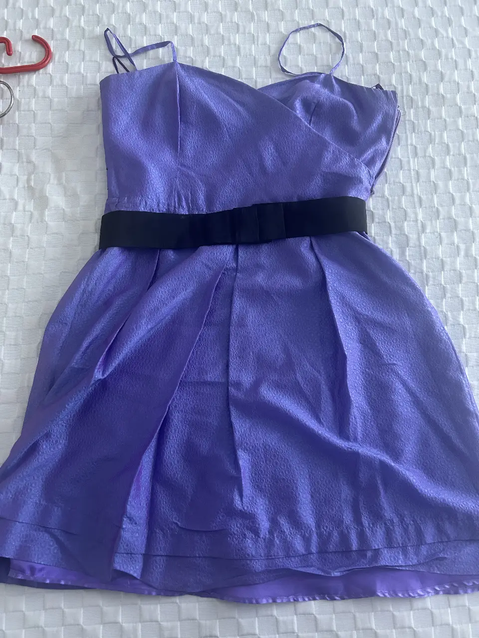 Vestido mini violeta con detalle de lazo negro en la cintura. Ideal para una fiesta o salida.