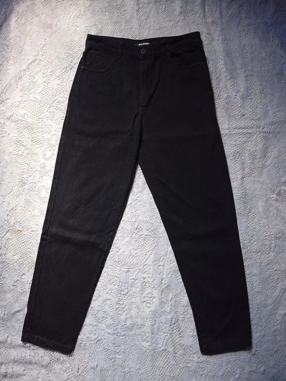 Pantalón de jean negro con cuatro bolsillos.