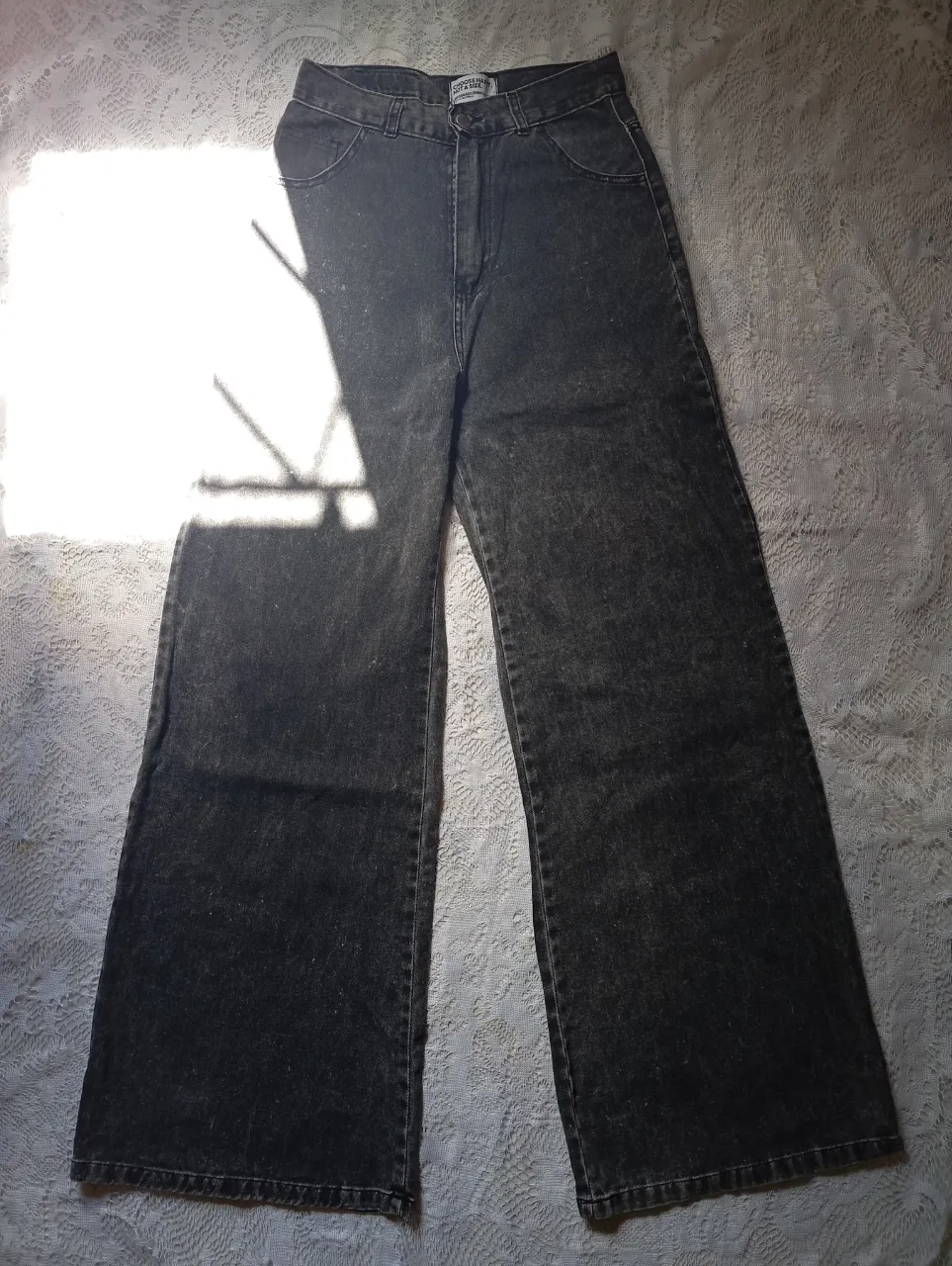 Jean wide leg tiro alto de moldería ancha, color gris oscuro con efecto desgastado.