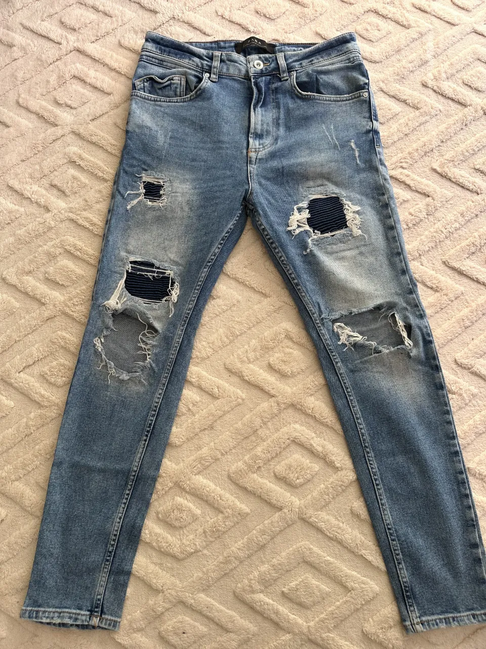 Jeans de tiro alto con roturas y detalles desgastados. Un clásico reinventado para un look canchero y moderno.