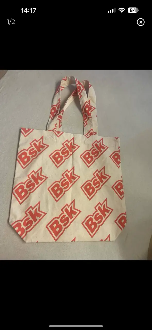 Bolso tote de tela con estampado repetido de la marca Bsk en color rojo sobre fondo blanco. Ideal para llevar tus cosas con estilo.