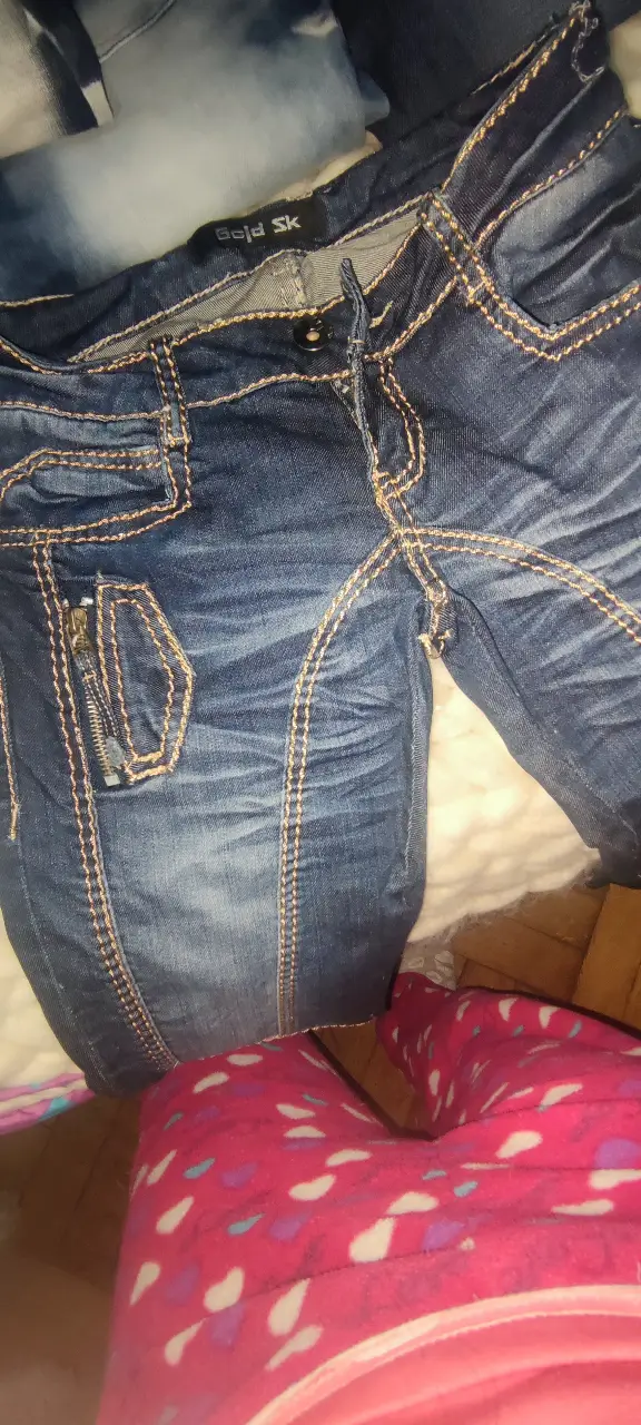 Jeans de mujer tiro bajo, con detalles de costuras en color amarillo y cierre con cremallera en el bolsillo. Talle 28.