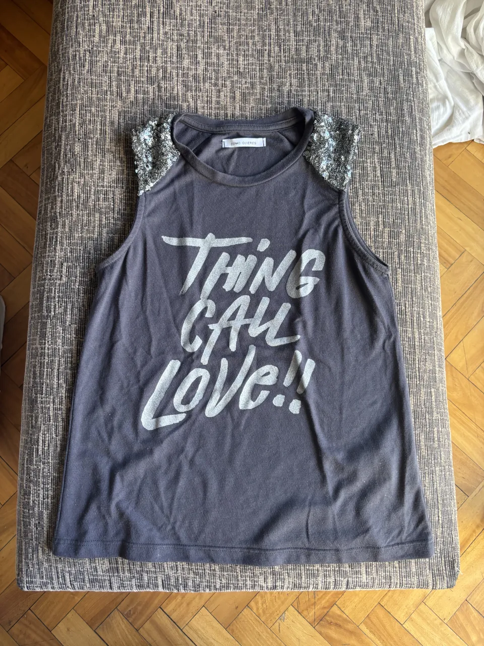 Musculosa gris con estampa "Thing call Love!!" y detalles de lentejuelas plateadas en los hombros. ¡Un toque de brillo para tu look!