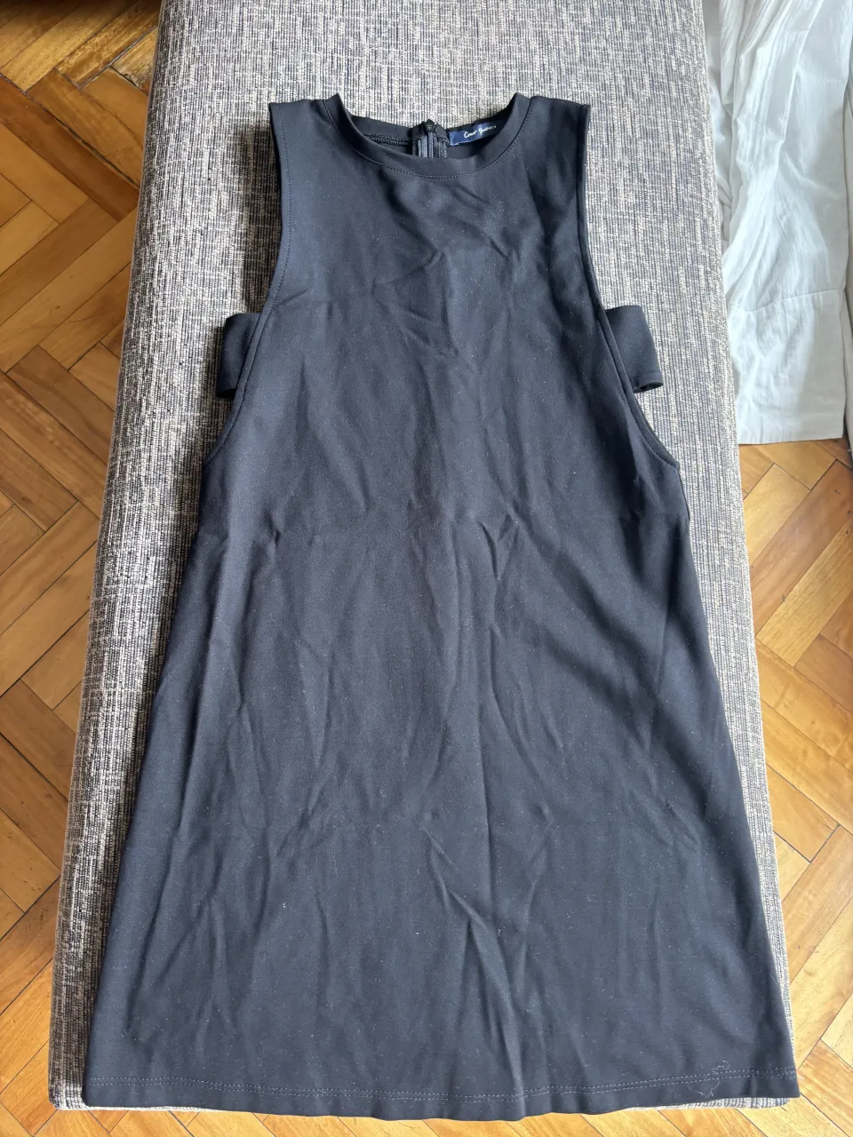 Vestido negro sin mangas, con escote redondo y detalles cut-out en los hombros. Ideal para un look casual o para salir.