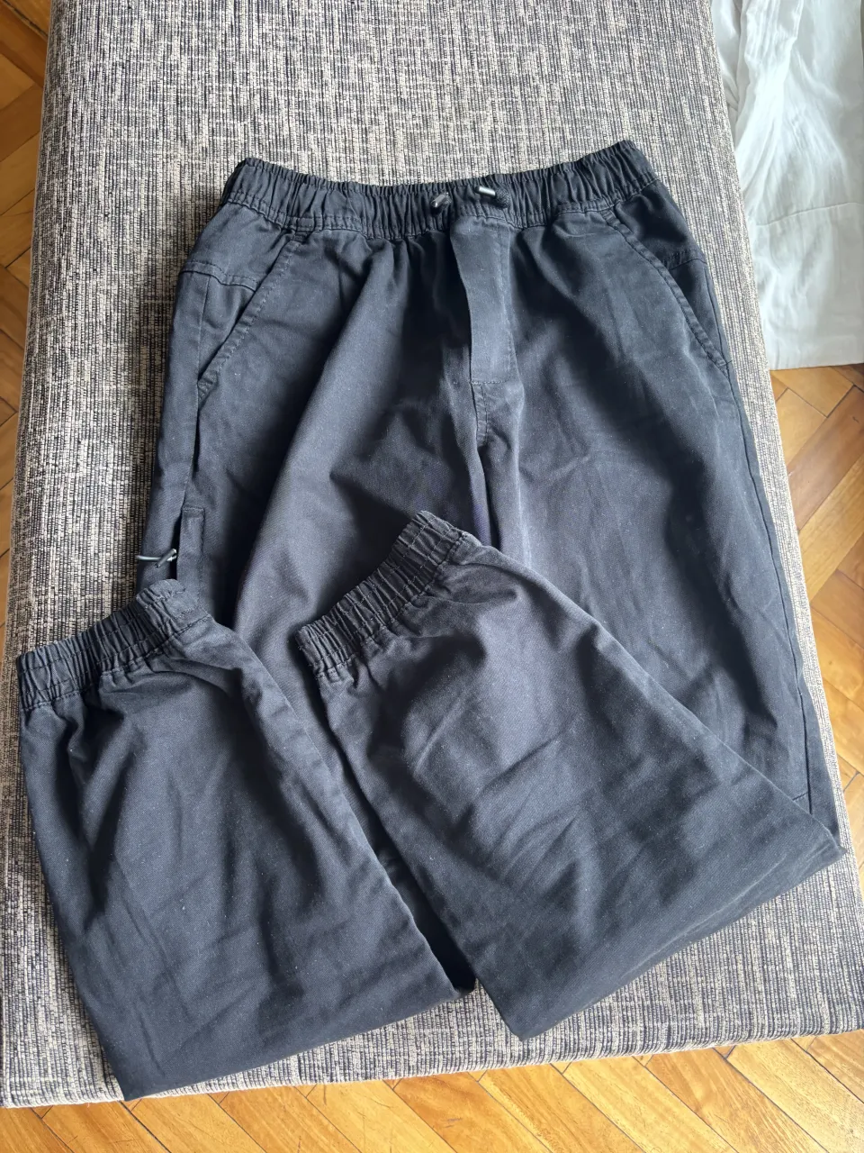 Pantalón cargo negro, tiro alto, con elástico en la cintura y puños. Ideal para un look urbano y cómodo.