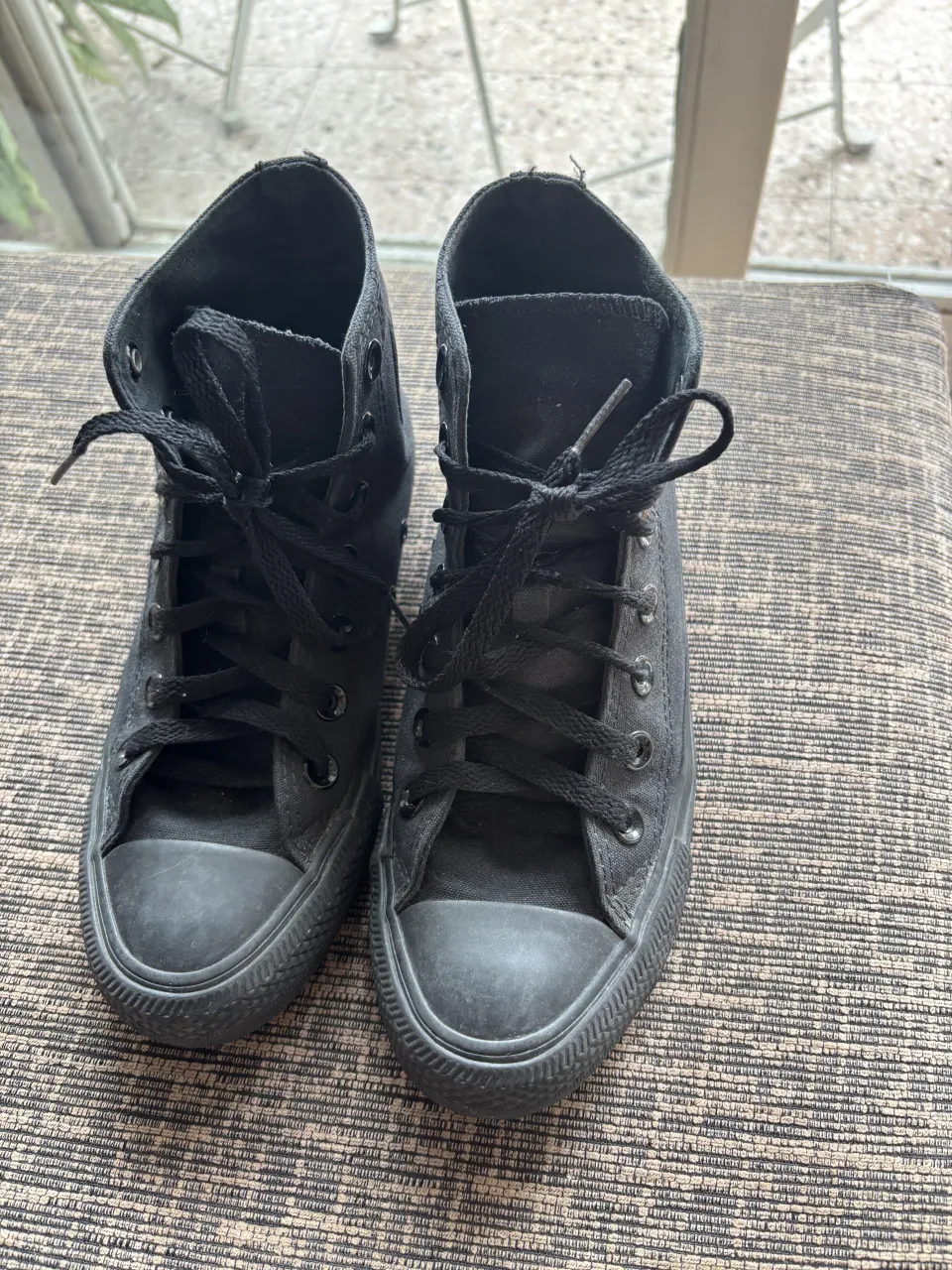 Zapatillas de lona negras, caña alta, con cordones. Ideales para un look urbano y casual.