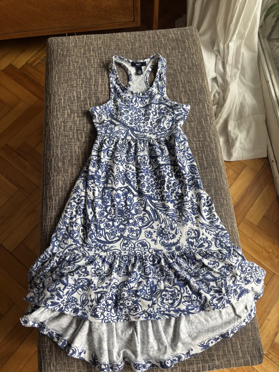 Vestido de verano estampado en blanco y azul, con volados en la falda. Ideal para días de calor y paseos.